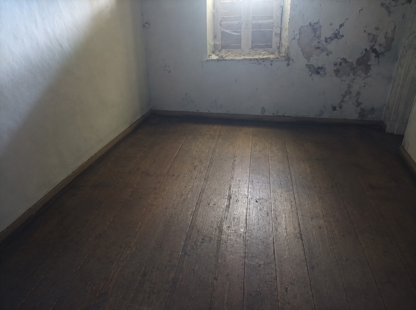 Chambre vidée après débarras, avec sol dégagé et espace libéré